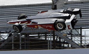 The car driven by Helio Castroneves, of Brazil, is airborne after hitting the wall in the first turn during practice for the Indianapolis 500 auto race at Indianapolis Motor Speedway in Indianapolis, Wednesday, May 13, 2015. (AP Photo/Joe Watts) ORG XMIT: NAA107